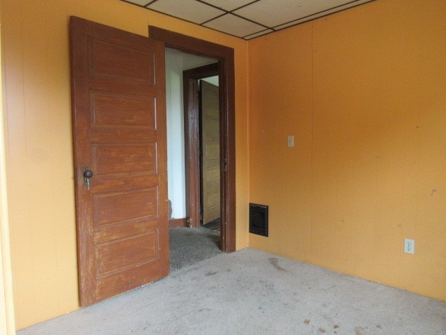 empty room featuring carpet floors and a paneled ceiling