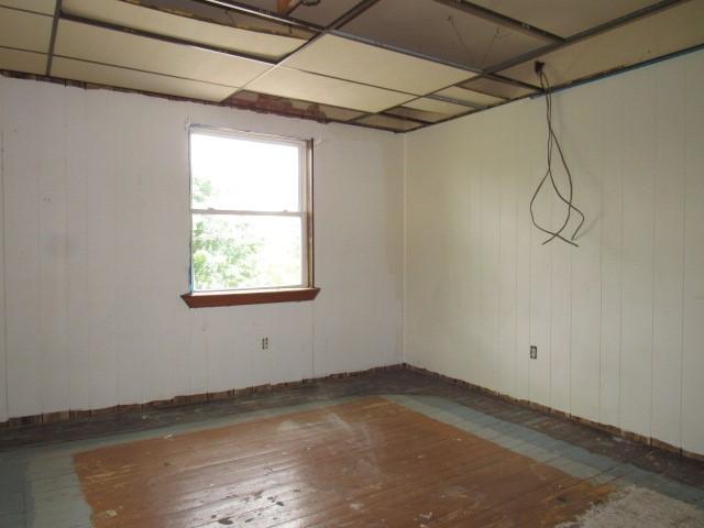 basement with hardwood / wood-style flooring and a drop ceiling