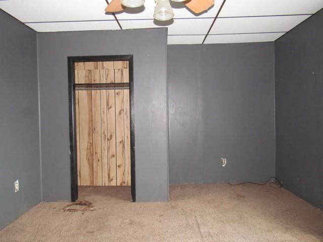 unfurnished bedroom featuring carpet and a paneled ceiling