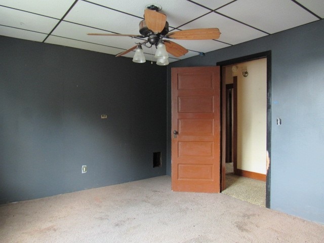 unfurnished bedroom with light carpet, a drop ceiling, and ceiling fan