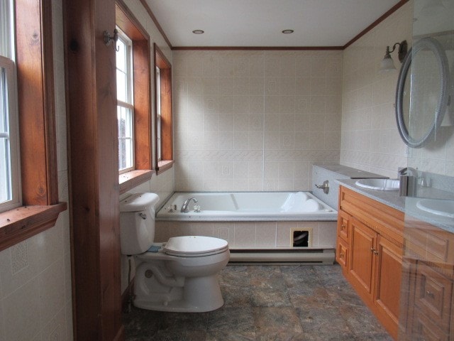 bathroom featuring tile patterned floors, plenty of natural light, tile walls, and a bathtub