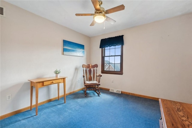 living area featuring carpet flooring and ceiling fan