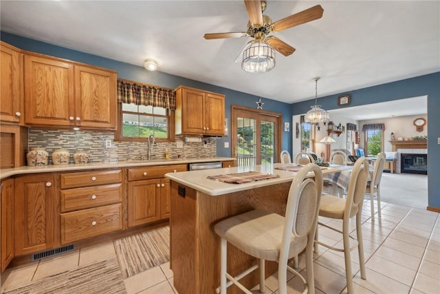 kitchen featuring decorative backsplash, a center island, sink, and hanging light fixtures