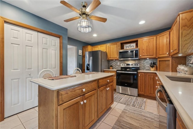 kitchen with a center island with sink, backsplash, light tile patterned floors, and stainless steel appliances