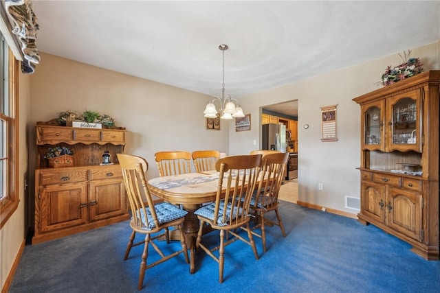 carpeted dining space featuring a chandelier