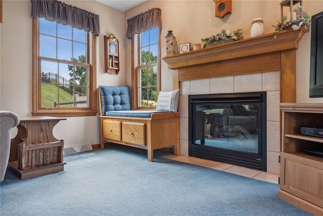 sitting room featuring carpet and a tile fireplace