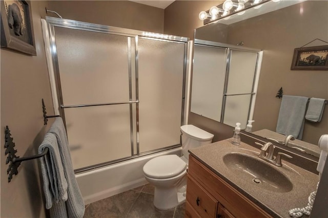 full bathroom featuring tile patterned flooring, vanity, combined bath / shower with glass door, and toilet