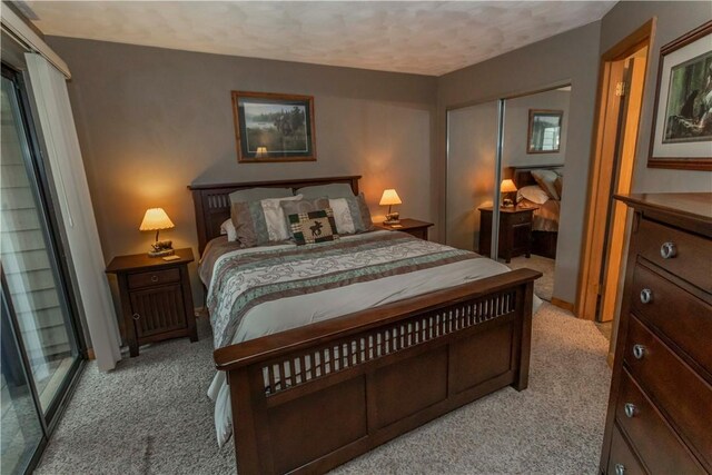 carpeted bedroom with a closet and a textured ceiling