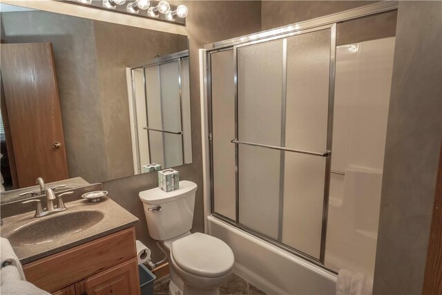 full bathroom featuring shower / bath combination with glass door, vanity, and toilet