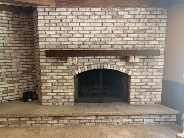 interior details featuring carpet floors and a brick fireplace