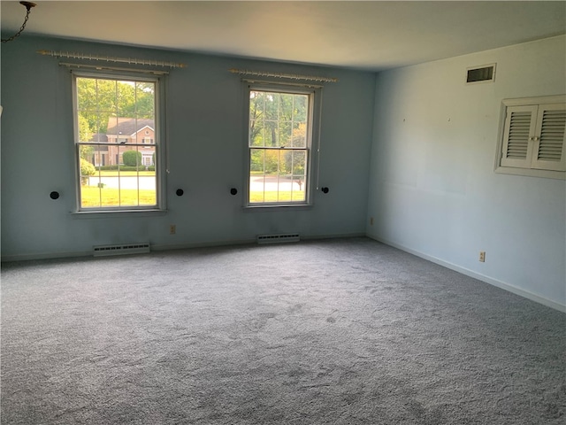 empty room with a baseboard heating unit and carpet floors