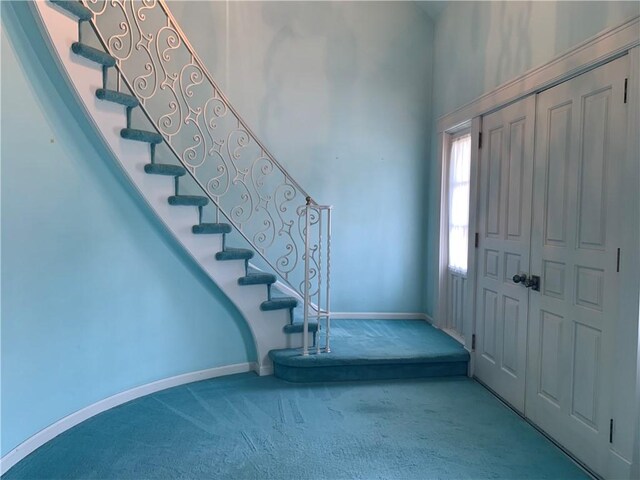 carpeted entrance foyer featuring a high ceiling