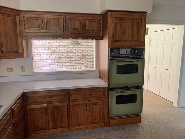 kitchen featuring double wall oven and light carpet