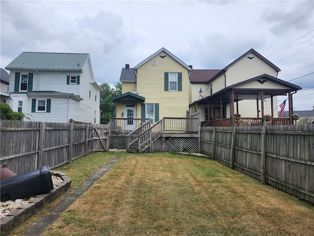 rear view of property featuring a yard and a wooden deck