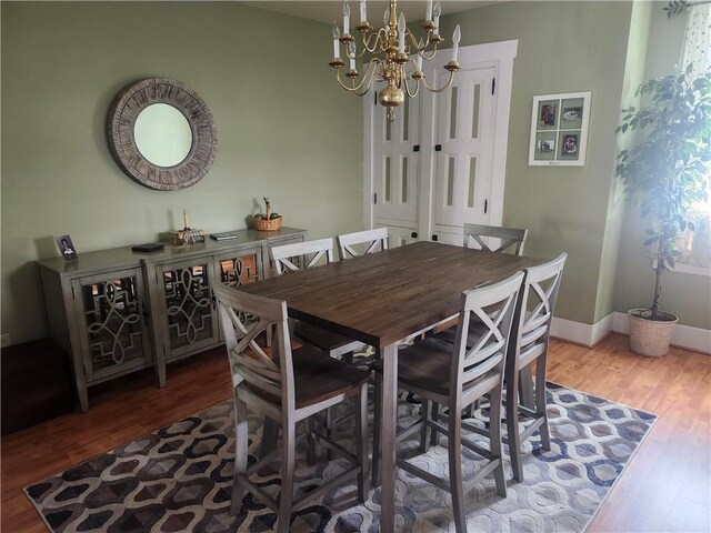 dining area with hardwood / wood-style flooring and a notable chandelier