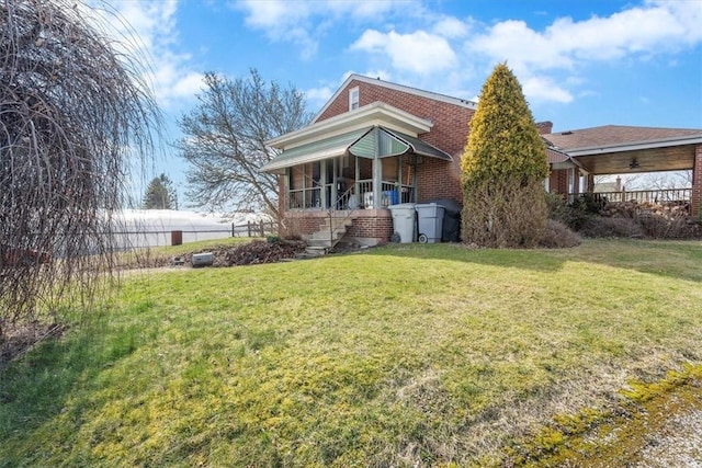 view of front facade with brick siding and a front lawn