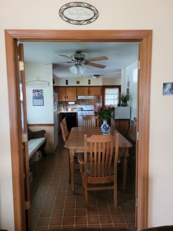 dining room featuring ceiling fan and dark tile patterned floors