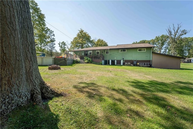 view of yard featuring a wooden deck and an outdoor fire pit