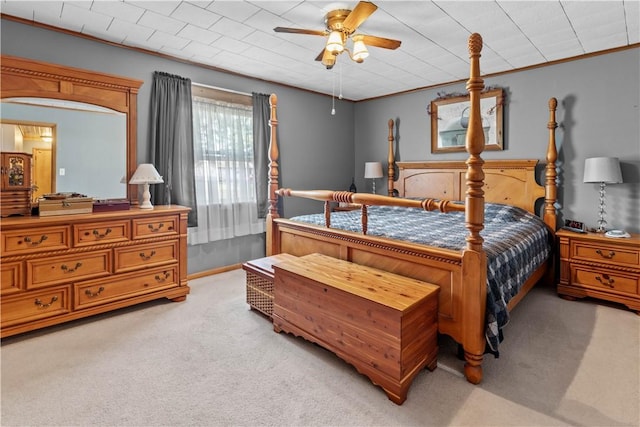 bedroom with light colored carpet, ceiling fan, and crown molding