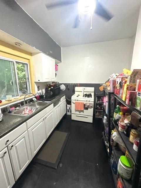 kitchen featuring sink, ceiling fan, white cabinets, and white range with gas stovetop