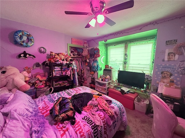 bedroom featuring carpet flooring, a textured ceiling, and ceiling fan