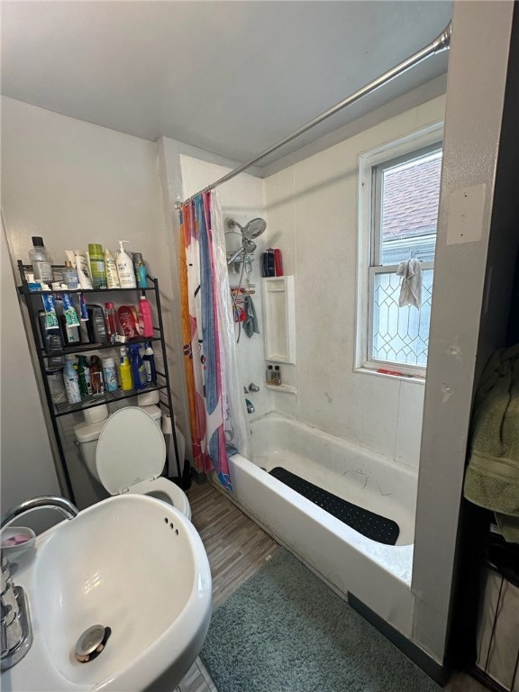 full bathroom with shower / bath combo with shower curtain, sink, toilet, and hardwood / wood-style flooring