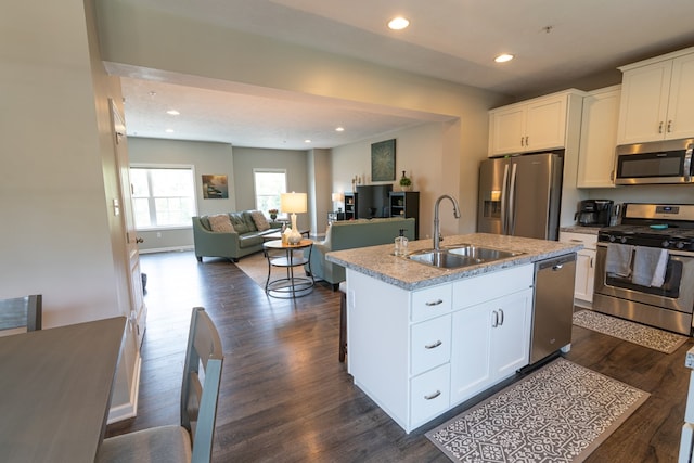 kitchen with a kitchen island with sink, appliances with stainless steel finishes, sink, and white cabinetry