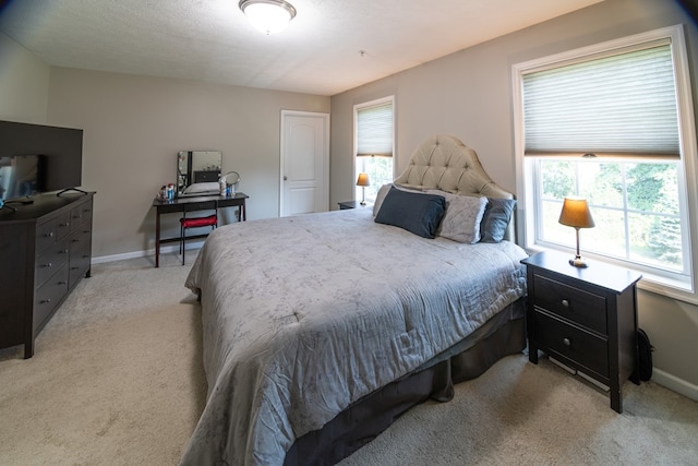 bedroom with multiple windows and light colored carpet