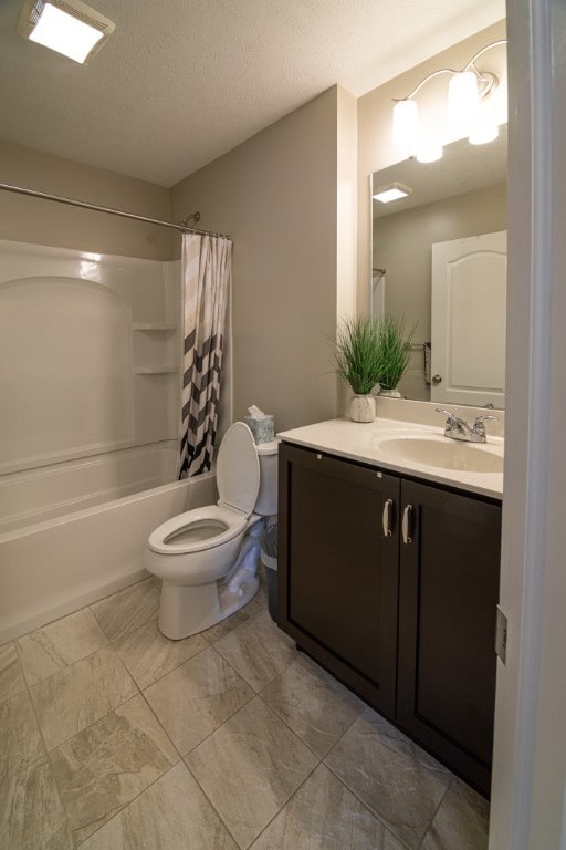 full bathroom with vanity, toilet, a textured ceiling, and shower / bath combo