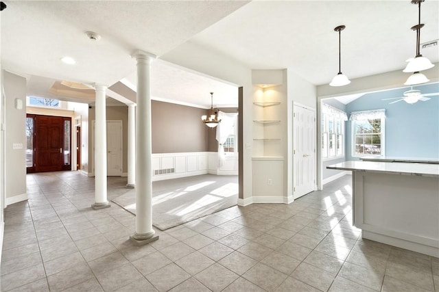 interior space with decorative columns, light tile patterned flooring, hanging light fixtures, and ceiling fan