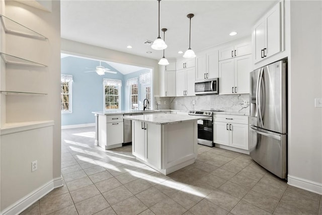 kitchen featuring white cabinetry, stainless steel appliances, a center island, and pendant lighting