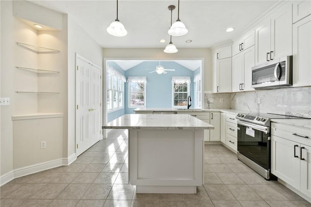 kitchen with white cabinetry, lofted ceiling, appliances with stainless steel finishes, and decorative backsplash