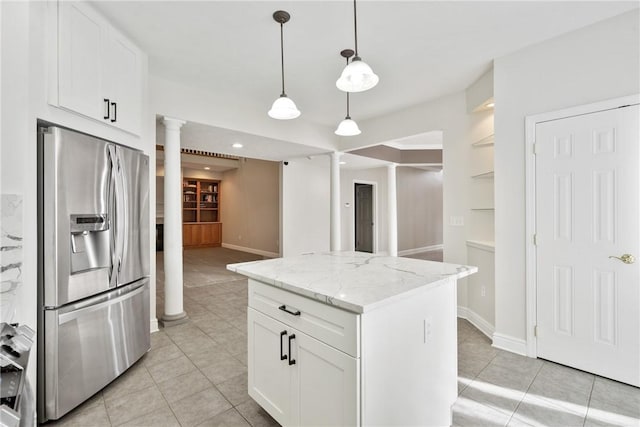 kitchen with white cabinetry, stainless steel fridge, light stone counters, and ornate columns