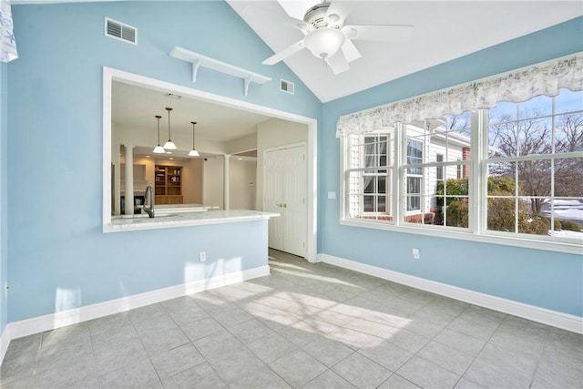 spare room with vaulted ceiling, sink, light tile patterned floors, and ceiling fan