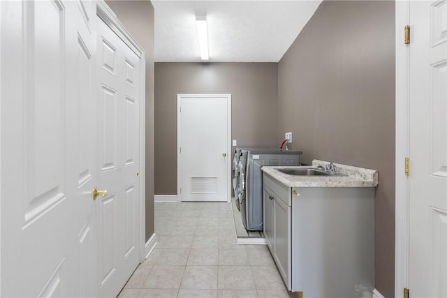 laundry room with cabinets, separate washer and dryer, sink, and light tile patterned floors