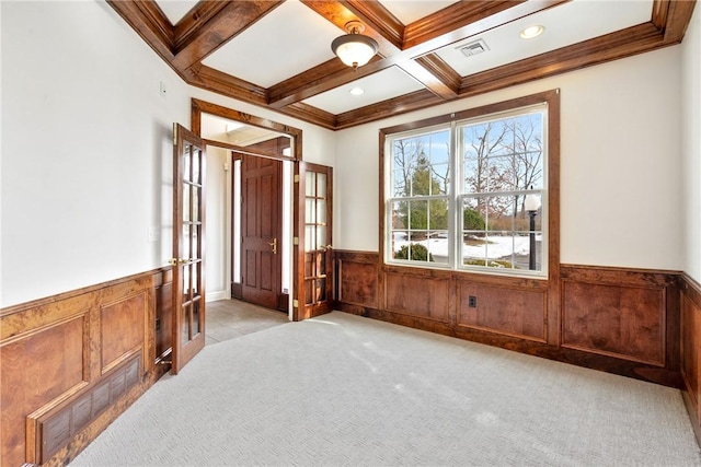 spare room featuring crown molding, light colored carpet, coffered ceiling, and beam ceiling