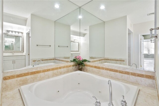 bathroom featuring vanity and tiled tub