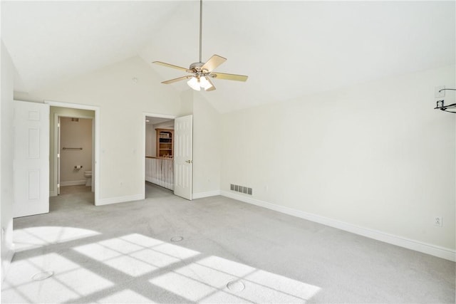 unfurnished bedroom with vaulted ceiling, light colored carpet, ceiling fan, and ensuite bathroom