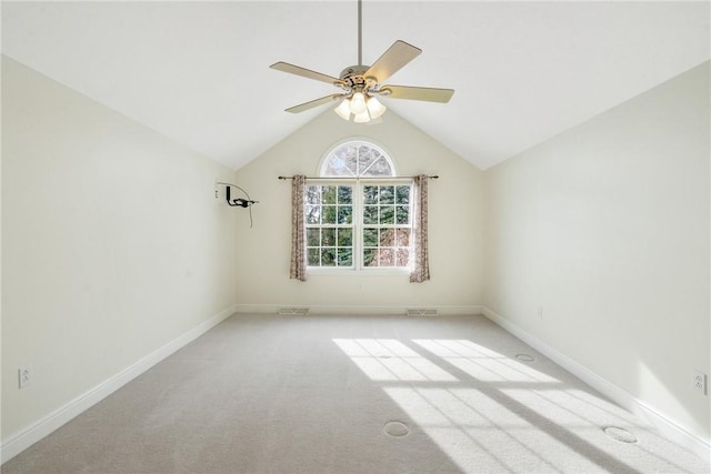 carpeted spare room with ceiling fan and vaulted ceiling