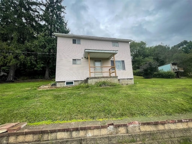 back of property featuring a porch and a yard