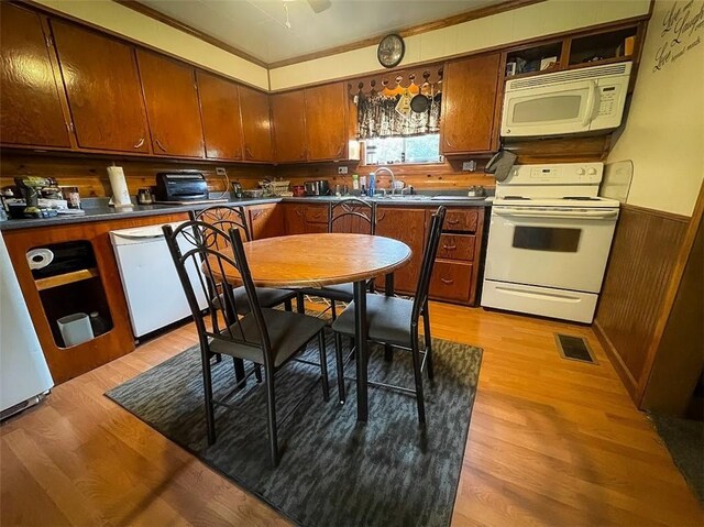 kitchen with crown molding, light hardwood / wood-style flooring, white appliances, and sink