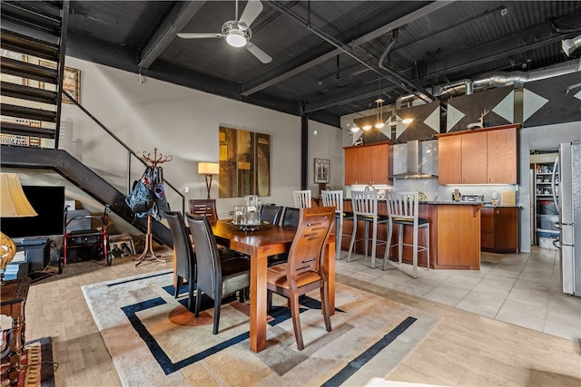 dining room featuring light hardwood / wood-style floors, a towering ceiling, and ceiling fan