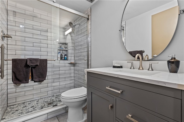 bathroom featuring tile patterned floors, vanity, a shower with door, and toilet