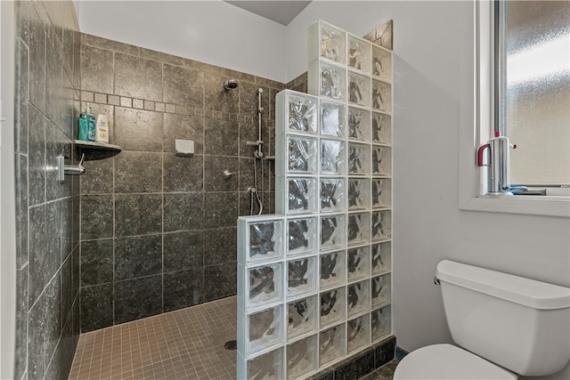 bathroom featuring tiled shower and toilet