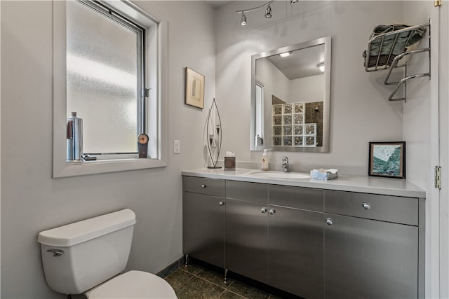 bathroom featuring a healthy amount of sunlight, vanity, toilet, and tile patterned floors