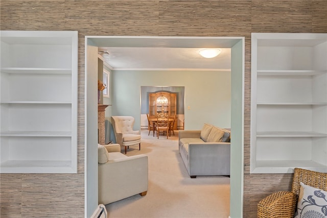 living room with built in shelves, light carpet, ornamental molding, and baseboard heating