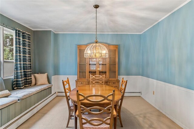 carpeted dining space with a baseboard heating unit, a notable chandelier, and ornamental molding