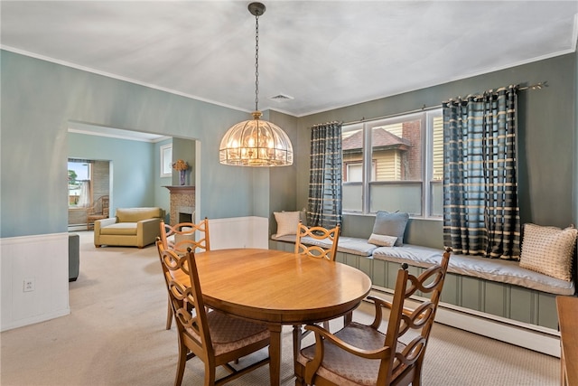 dining room with a chandelier, light carpet, crown molding, and a baseboard heating unit