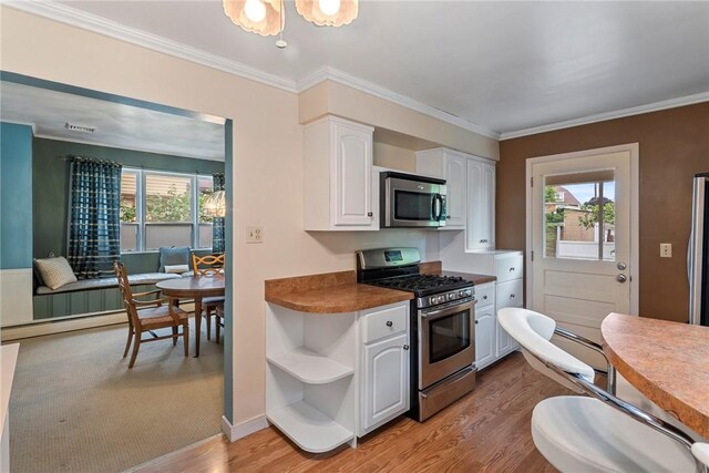 kitchen featuring range, light hardwood / wood-style floors, ornamental molding, and white cabinets