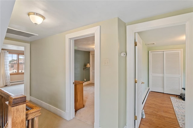 hallway with light hardwood / wood-style floors and baseboard heating